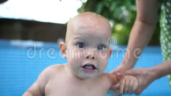 一岁的孩子在水池里的水流下训练一个一岁的孩子训练你的呼吸和视频的预览图