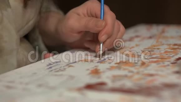 女性的手在画布上画一个薄薄的流苏视频的预览图