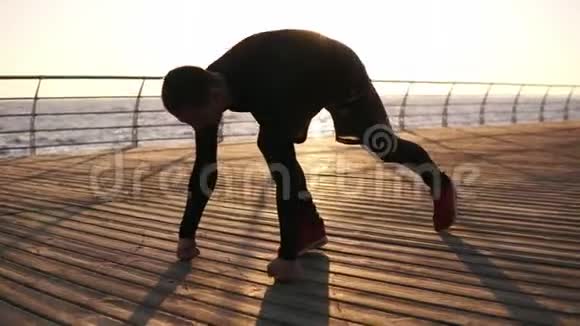 年轻的运动员在户外用他的拳头在大海或海洋前的木制泡沫上做俯卧撑健身和锻炼视频的预览图