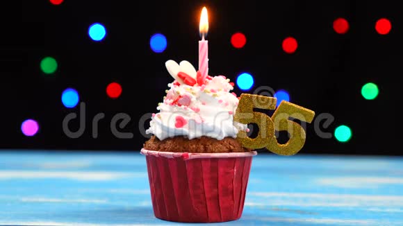 带有蜡烛的美味生日蛋糕和55号的彩色模糊灯光背景视频的预览图