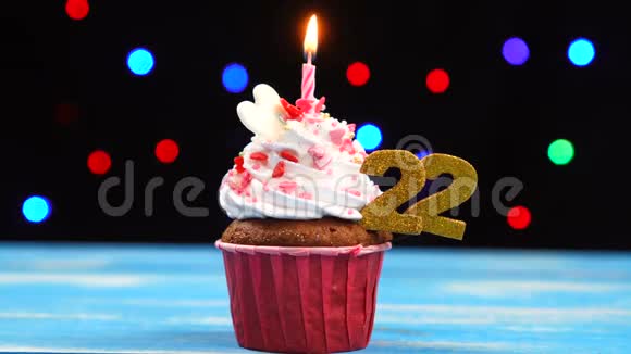 带有蜡烛的美味生日蛋糕和22号的彩色模糊灯光背景视频的预览图