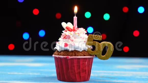 带有蜡烛的美味生日蛋糕和50号的彩色模糊灯光背景视频的预览图