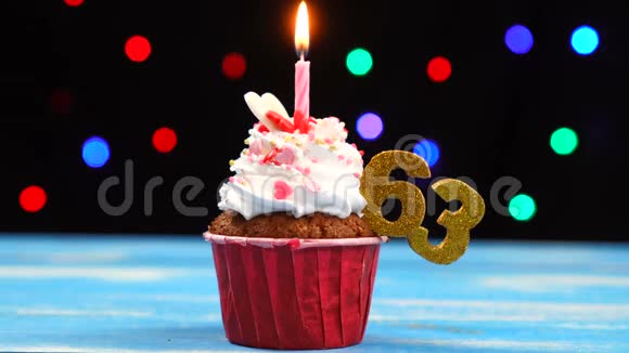 带有蜡烛的美味生日蛋糕和63号的彩色模糊灯光背景视频的预览图