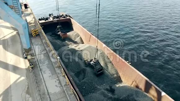 一辆起重机从驳船上抓起瓦砾堆成一堆视频的预览图