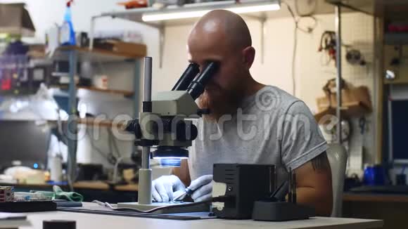 技术人员正在服务中心通过显微镜焊接微芯片视频的预览图