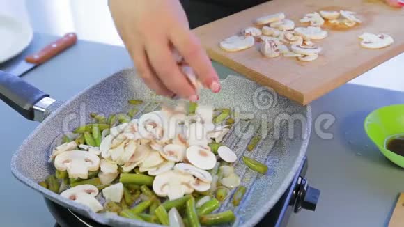 女人把切好的香瓜和青豆加到锅里视频的预览图