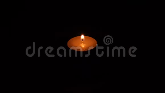 一支明亮的蜡烛在黑色背景下燃烧视频的预览图