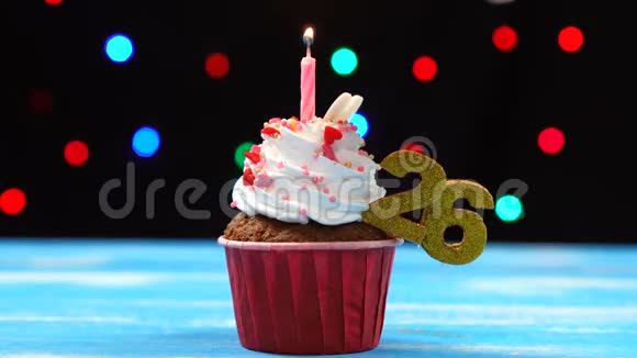 带有蜡烛的美味生日蛋糕和26号的彩色模糊灯光背景视频的预览图