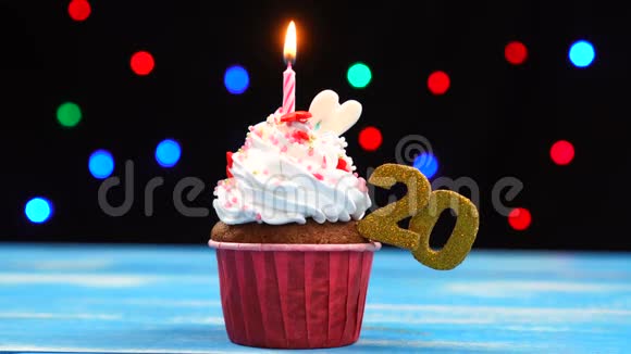 带有蜡烛的美味生日蛋糕和20号的彩色模糊灯光背景视频的预览图