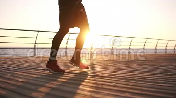 拳击手站在日出前的海面上的木地板上做练习腿耐力训练视频的预览图