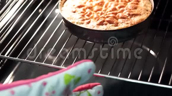 在烤箱里煮苹果派家庭主妇把蛋糕从烤箱里拿出来视频的预览图