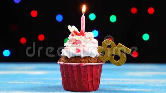 带有蜡烛的美味生日蛋糕和85号的彩色模糊灯光背景视频的预览图