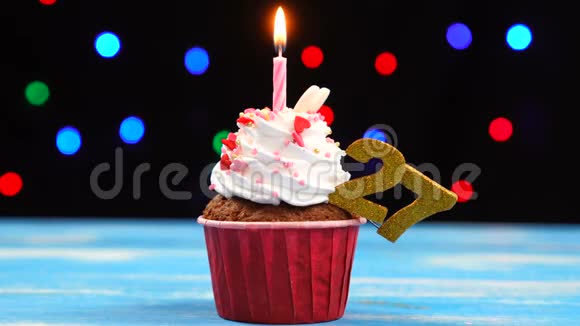 带有蜡烛的美味生日蛋糕和27号的彩色模糊灯光背景视频的预览图