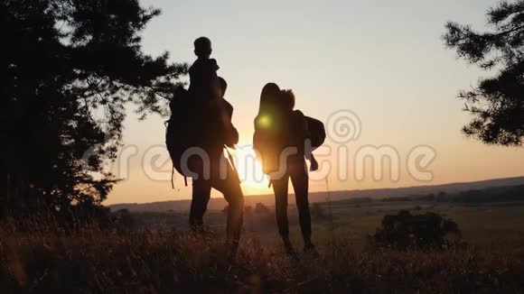 一个幸福的家庭家庭旅行和徒步穿越森林在日落露天行走团队合作健康视频的预览图
