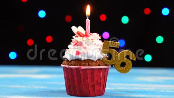 带有蜡烛的美味生日蛋糕和56号的彩色模糊灯光背景视频的预览图