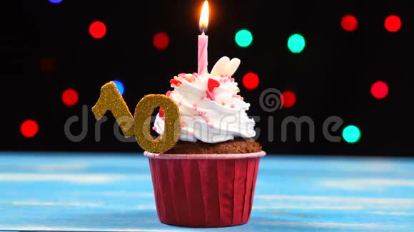 带有蜡烛的美味生日蛋糕和彩色模糊灯光背景上的10号蛋糕视频的预览图
