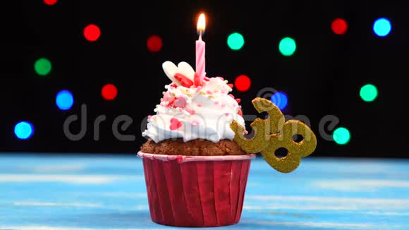 带有蜡烛的美味生日蛋糕和38号的彩色模糊灯光背景视频的预览图