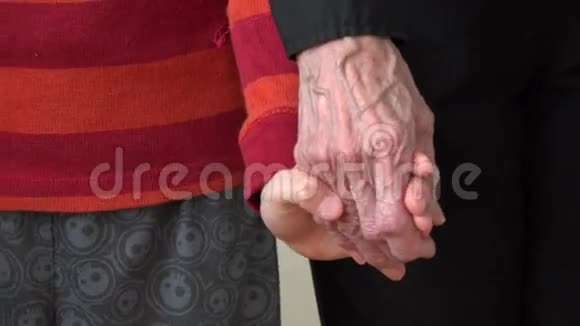 孩子的手握着祖母那只皱巴巴的老手视频的预览图