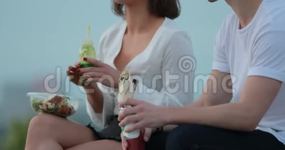 年轻夫妇坐在城市堤边吃沙拉视频的预览图