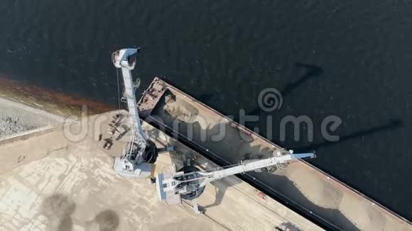 一辆起重机用碎石卸大驳船把它搬成堆视频的预览图