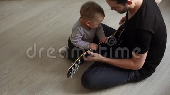 小可爱的宝宝在爸爸弹吉他时好奇地听着视频的预览图