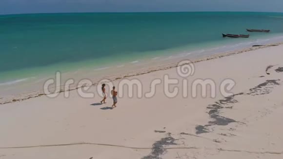 在菲律宾一对旅伴在蔚蓝的沙滩上漫步视频的预览图