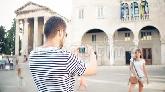 一对年轻的幸福夫妇在度假时在旅游地拍照视频的预览图