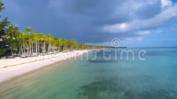 美丽的空中飞行在热带天堂岛海滩与步行游客棕榈和酒店度假地区视频的预览图