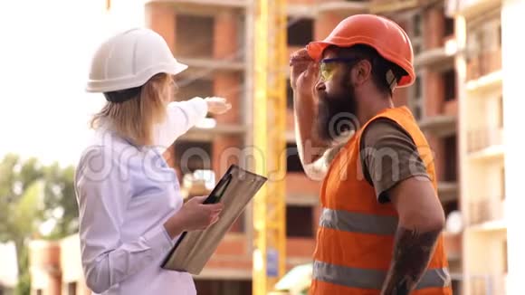 讨论进度计划检查员和留胡子的野蛮建筑工人讨论施工进度建设项目视频的预览图