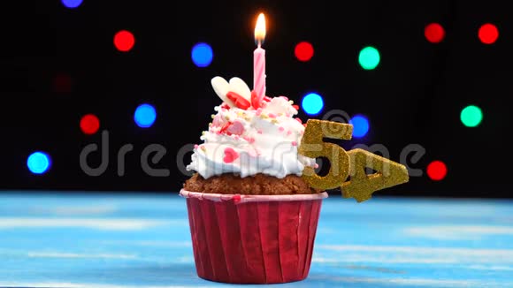 带有蜡烛的美味生日蛋糕和54号的彩色模糊灯光背景视频的预览图