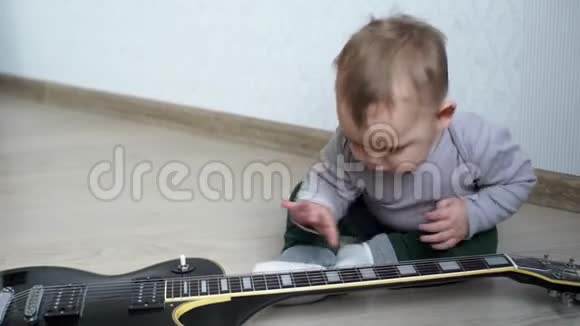 可爱的小宝宝好奇地学吉他视频的预览图