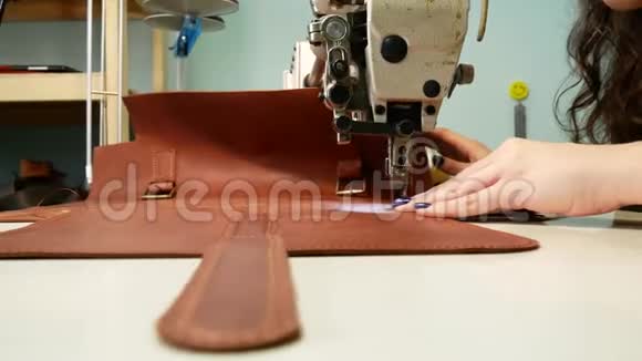 女裁缝在缝纫车间把一个口袋缝在皮包上一个女人操作缝纫机奴隶工作概念视频的预览图