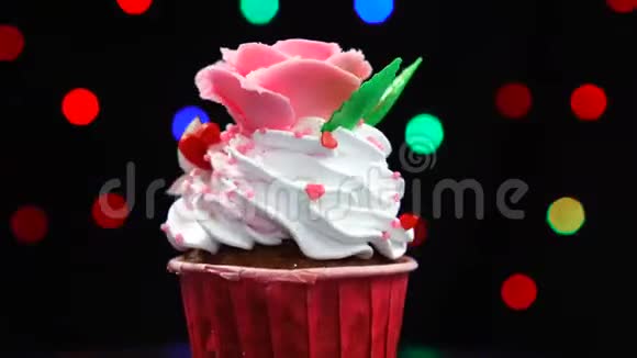 以玫瑰为装饰的香草纸杯蛋糕在浅色背景下快速旋转视频的预览图