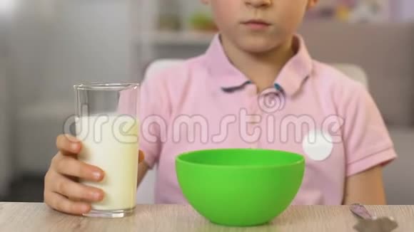 男生在碗里倒牛奶加麦片美味健康的早餐关门视频的预览图