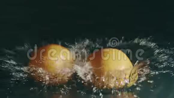 两个桔子落在浅水面上慢镜头红色镜头视频的预览图