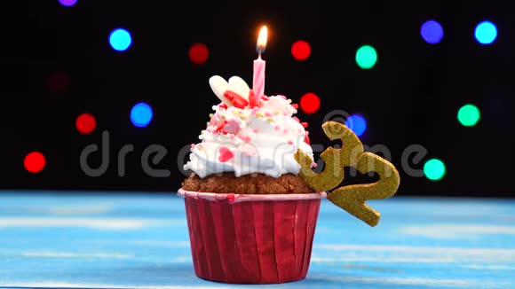 带有蜡烛的美味生日蛋糕和32号的彩色模糊灯光背景视频的预览图
