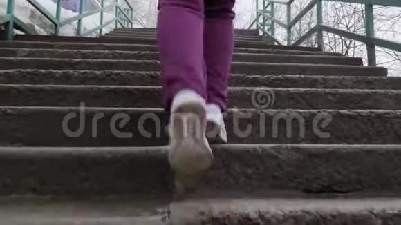 一个女孩穿着白色跑鞋跑上楼梯台阶的特写镜头慢镜头后拍视频的预览图