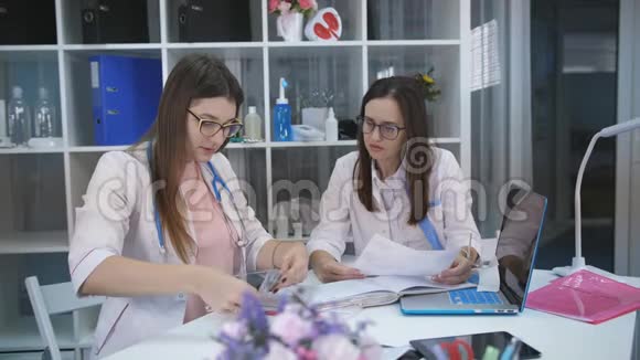 两名妇女医生办公室考虑x光并讨论下一步治疗病人视频的预览图