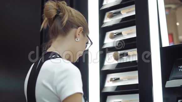 年轻女孩在商店里看化妆品视频的预览图
