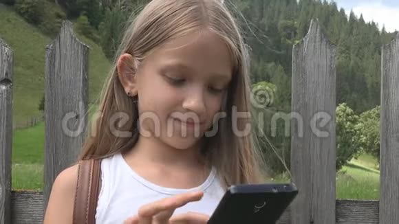 儿童户外玩智能手机儿童浏览平板电脑女孩自然放松视频的预览图