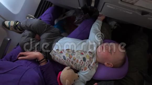 小可爱的宝宝睡在飞机上慢动作躺在爸爸妈妈身上视频的预览图