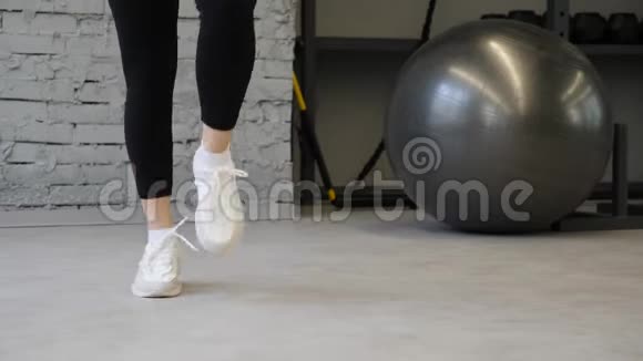 这个视频是关于特写女性健身白鞋的在健身房或家里锻炼有氧运动美丽的腿的细节视频的预览图