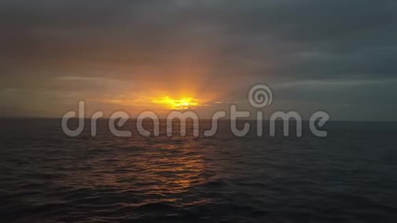缓慢的低飞在海浪之上朝着美丽的彩色日落空中无人机在露天拍摄美丽的夜晚视频的预览图