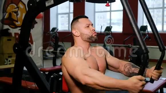 健美运动员在健身室锻炼身体克服疲劳健身用举重机做运动的人视频的预览图
