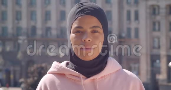 年轻迷人的非裔美国穆斯林女孩在城市户外看镜头的特写镜头视频的预览图