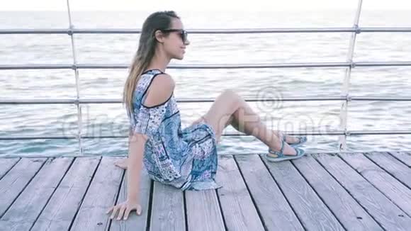 背面观看一位年轻美丽的女人穿着轻盈的夏装在大海和夜空的背景下年轻漂亮视频的预览图