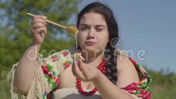 美丽的超重女人在户外吃蜂蜜煎饼的肖像健康自制食品与视频的预览图