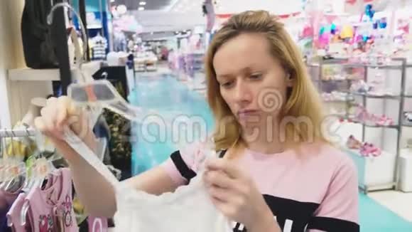 女人在儿童服装店挑选新衣服视频的预览图