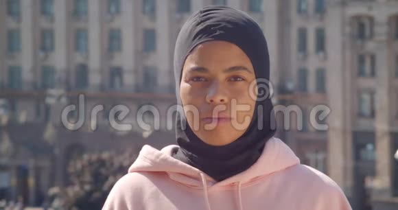年轻迷人的非裔美国穆斯林女孩在城市户外看摄像机的特写镜头视频的预览图