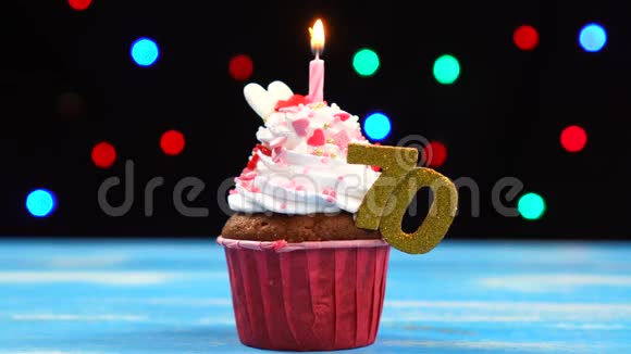 带有蜡烛的美味生日蛋糕和70号的彩色模糊灯光背景视频的预览图